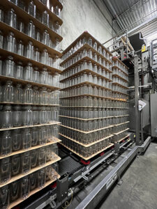 Empty milk bottles are shown stacked on a shelf.